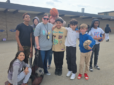 teacher surrounded by students at recess
